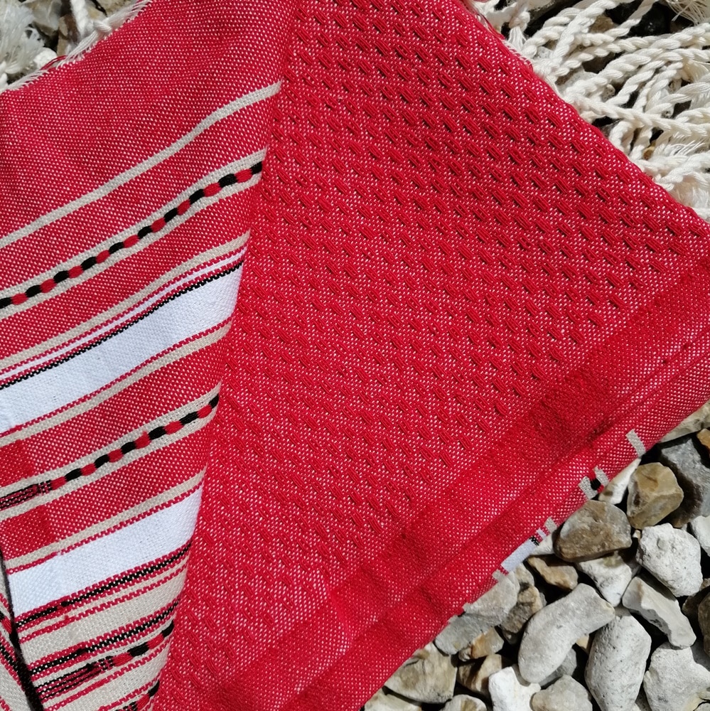 Vibrant red coloured with narrow pink and white stripes at each end of the towel.